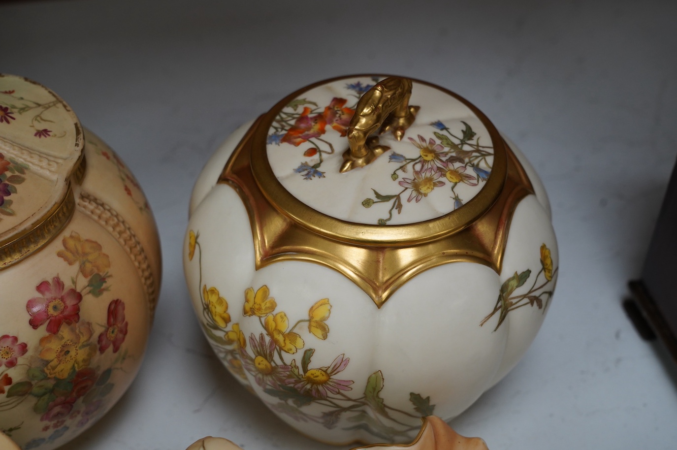 Two Worcester blush ivory biscuit jars and covers, numbers 1412 and 1796, a shell dish, number 971 and a vase, number 1877, tallest 17cm. Condition - mostly good, some wear to gilding